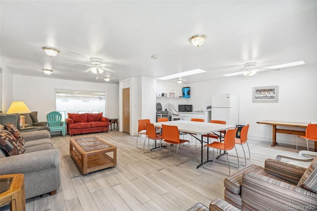 7995 E Mississippi Ave Unit A4, Denver, CO 80247 - living area featuring a ceiling fan, a skylight, and light wood finished floors