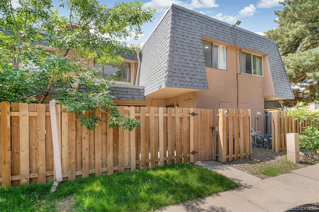 7995 E Mississippi Ave Unit A4, Denver, CO 80247 - view of side of property with mansard roof, a shingled roof, and a gate
