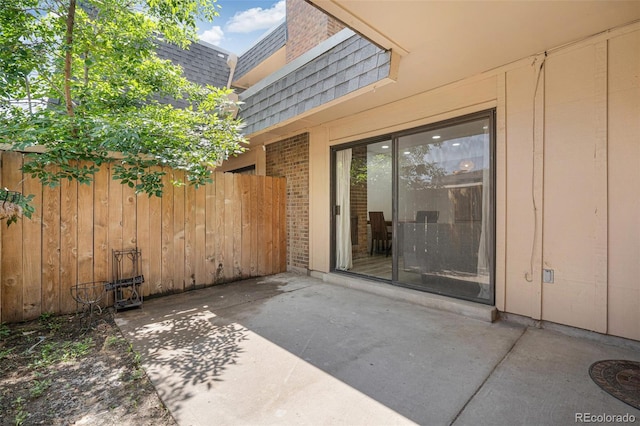 7995 E Mississippi Ave Unit A4, Denver, CO 80247 - property entrance with a patio area, roof with shingles, brick siding, and mansard roof
