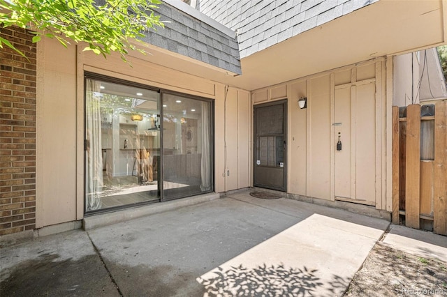 7995 E Mississippi Ave Unit A4, Denver, CO 80247 - doorway to property with board and batten siding, a patio, mansard roof, and roof with shingles
