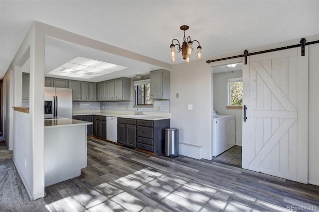255 Park View Dr, Fairplay, CO 80440 - kitchen featuring gray cabinets, washing machine and dryer, a barn door, dishwasher, and stainless steel fridge with ice dispenser