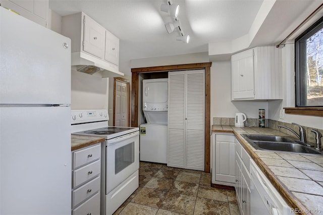 255 Park View Dr, Fairplay, CO 80440 - kitchen with tile countertops, stacked washer / drying machine, a sink, under cabinet range hood, and white appliances