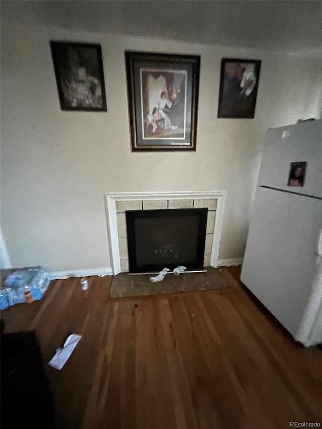 1900 Quebec St, Denver, CO 80220 - detailed view of freestanding refrigerator, a tiled fireplace, wood finished floors, and baseboards