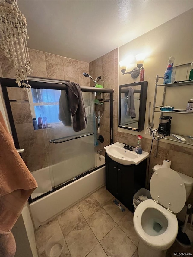 1900 Quebec St, Denver, CO 80220 - full bath featuring tile walls, shower / bath combination with glass door, vanity, toilet, and tile patterned floors