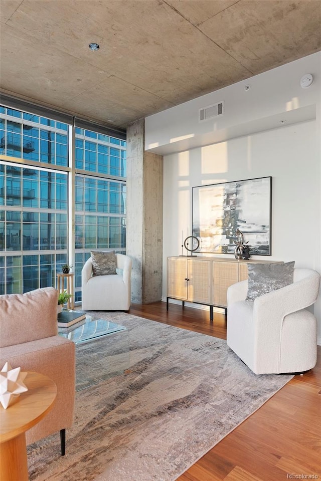 living room with a wall of windows and hardwood / wood-style flooring