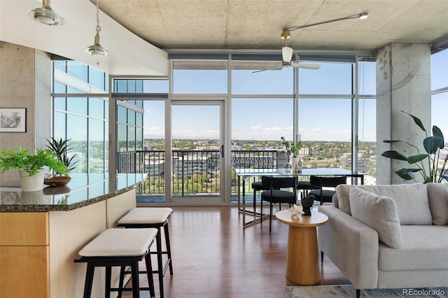 living room featuring ceiling fan, dark hardwood / wood-style flooring, and expansive windows