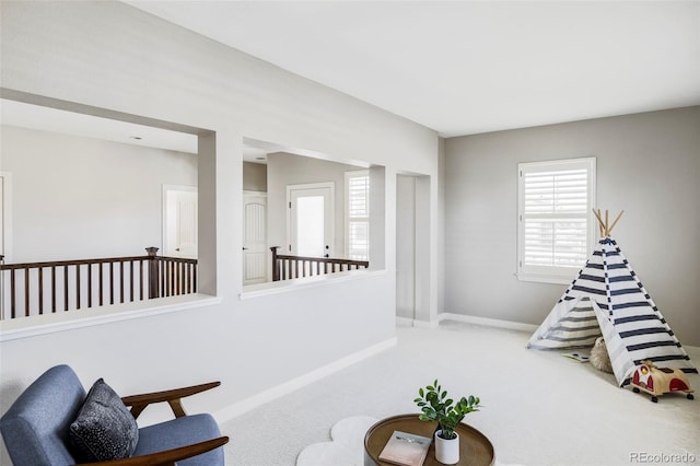 sitting room featuring light colored carpet