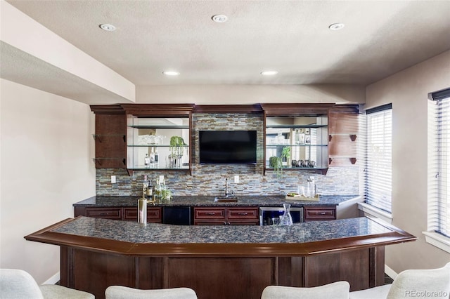 bar featuring tasteful backsplash, sink, and beverage cooler