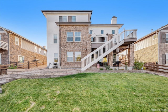 rear view of house with a yard and a deck