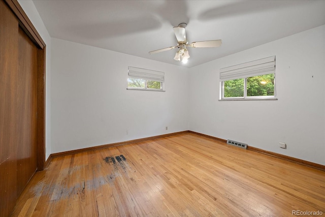7077 Dudley Dr, Arvada, CO 80004 - unfurnished bedroom featuring multiple windows, a closet, hardwood / wood-style floors, and a ceiling fan