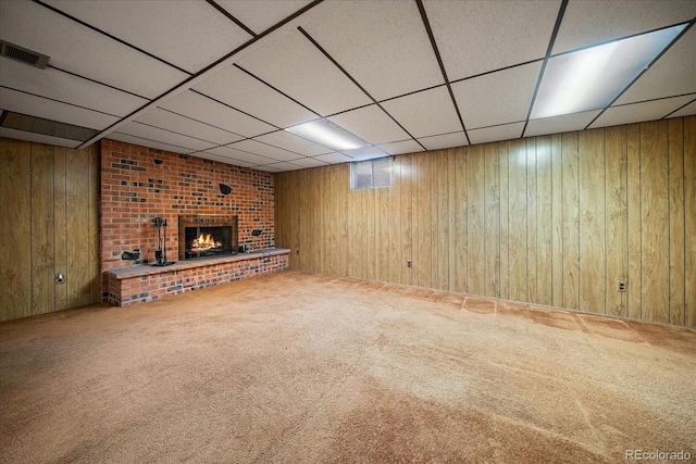 7077 Dudley Dr, Arvada, CO 80004 - unfurnished living room with wood walls, carpet, a fireplace, and a paneled ceiling
