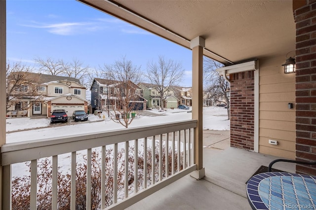 snow covered back of property with covered porch