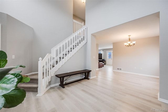 staircase featuring hardwood / wood-style floors and a chandelier