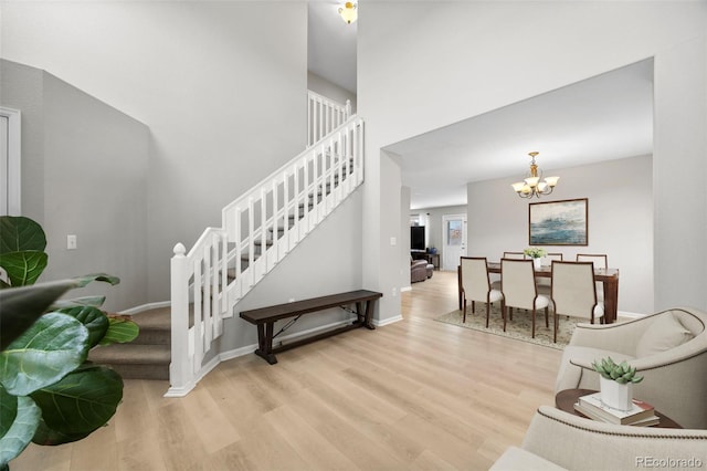 staircase with hardwood / wood-style flooring and an inviting chandelier