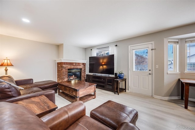 living room with light wood-type flooring and a fireplace