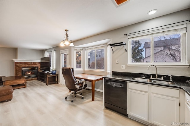 kitchen with white cabinetry, sink, black dishwasher, a chandelier, and pendant lighting