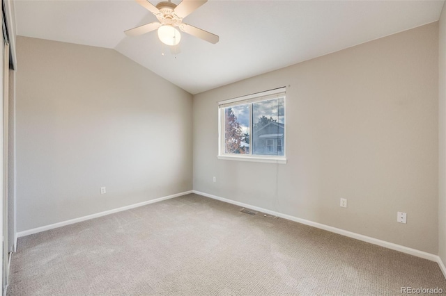 carpeted spare room with ceiling fan and vaulted ceiling