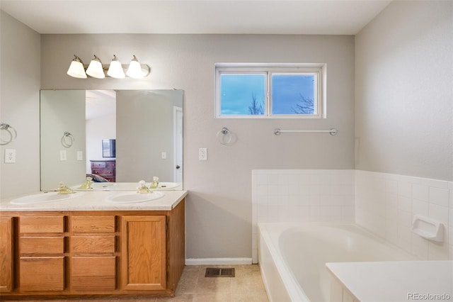 bathroom featuring tile patterned floors, a tub, and vanity