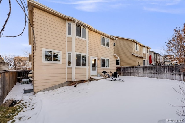 view of snow covered back of property