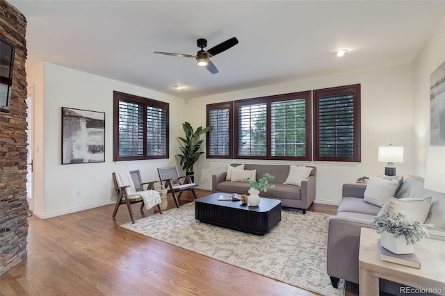 living room with baseboards, a ceiling fan, and wood finished floors