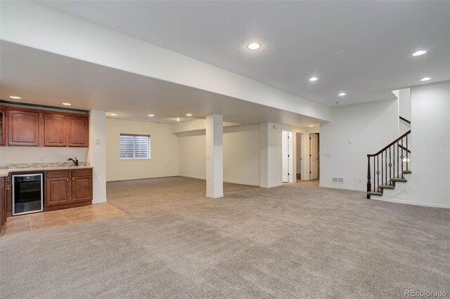 below grade area with wet bar, stairway, beverage cooler, light carpet, and recessed lighting