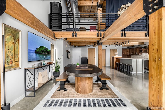 2955 Inca St Unit 1H, Denver, CO 80202 - dining area featuring concrete floors, a towering ceiling, and stairs