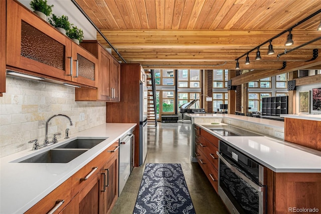 2955 Inca St Unit 1H, Denver, CO 80202 - kitchen with appliances with stainless steel finishes, wood ceiling, brown cabinetry, plenty of natural light, and open floor plan