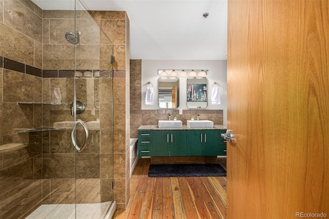 2955 Inca St Unit 1H, Denver, CO 80202 - bathroom featuring a stall shower, hardwood / wood-style floors, double vanity, a tub to relax in, and tile walls