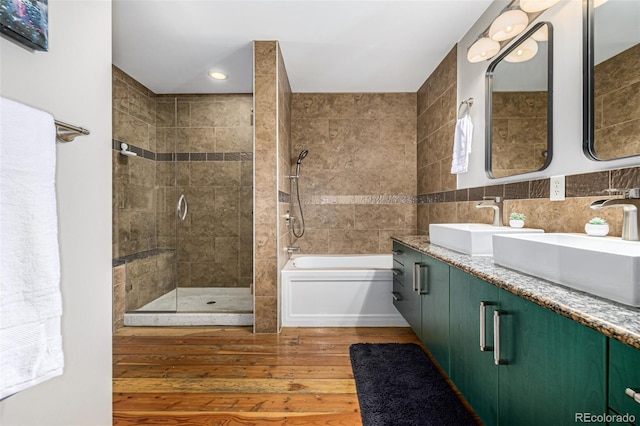 2955 Inca St Unit 1H, Denver, CO 80202 - full bath with tiled shower, a tub to relax in, double vanity, wood finished floors, and tile walls
