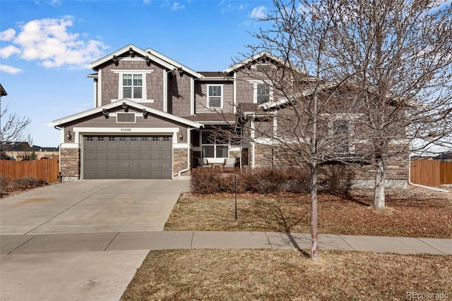 craftsman-style house with stone siding, driveway, an attached garage, and fence