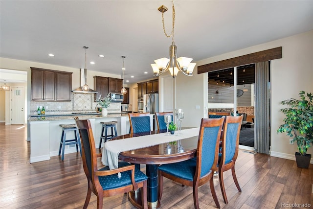 dining room with a chandelier, recessed lighting, dark wood-type flooring, and baseboards