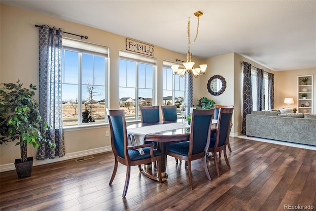 dining area with visible vents, baseboards, dark wood-type flooring, and an inviting chandelier