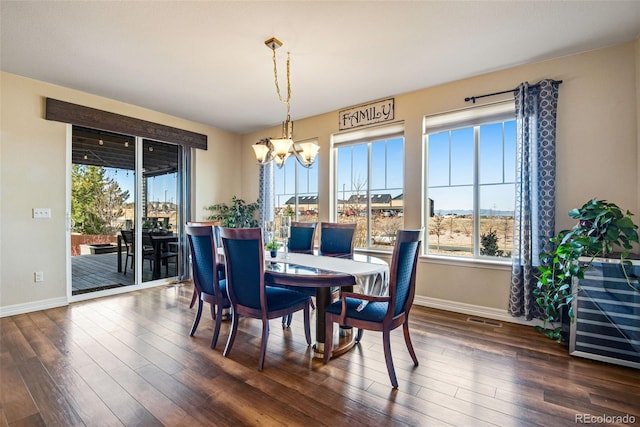 dining space featuring dark wood finished floors, visible vents, baseboards, and an inviting chandelier