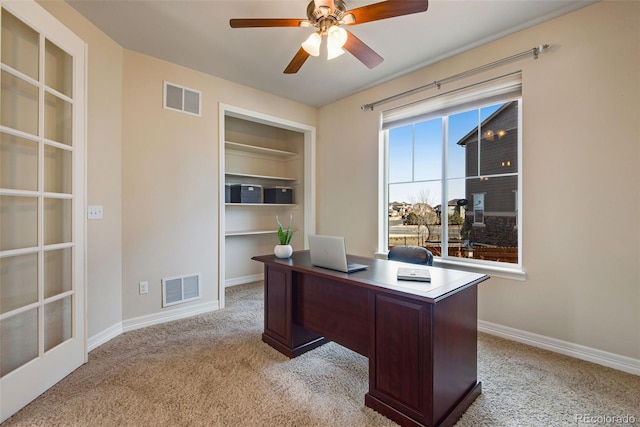 office with ceiling fan, light colored carpet, visible vents, and baseboards