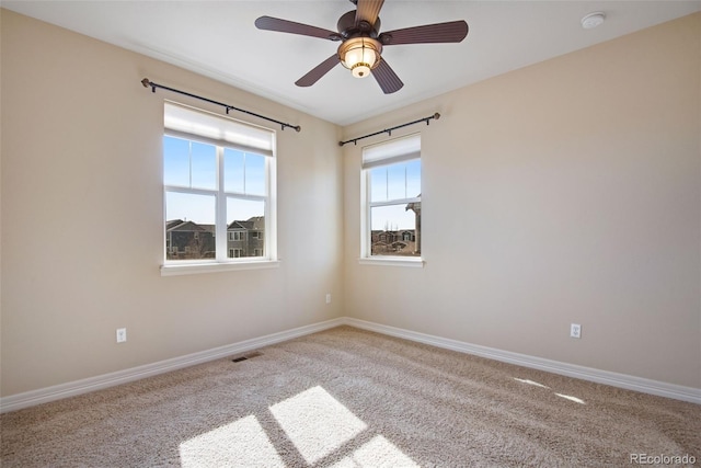 unfurnished room with a ceiling fan, carpet flooring, baseboards, and visible vents