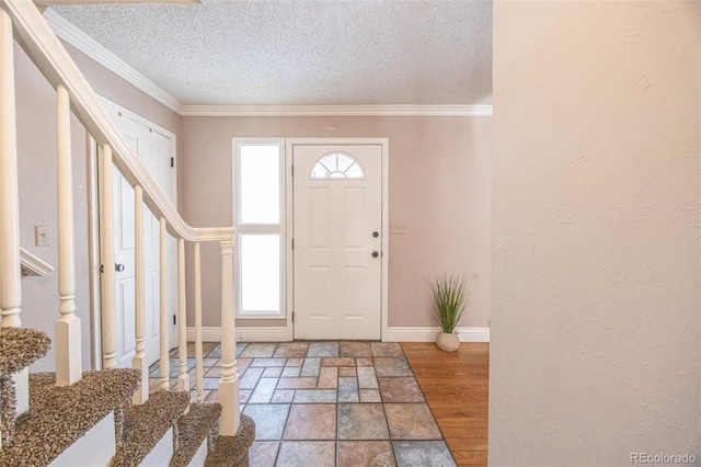 foyer entrance featuring crown molding, wood-type flooring, and a textured ceiling