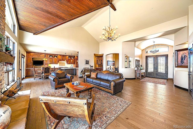 living area with high vaulted ceiling, wooden ceiling, a chandelier, and light wood-style floors