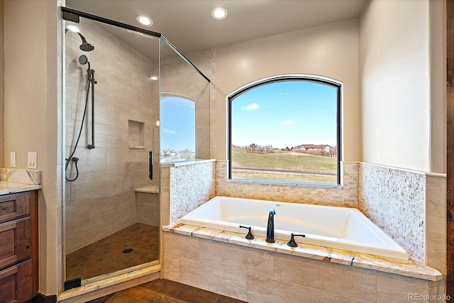 full bath featuring a garden tub, vanity, recessed lighting, and a shower stall
