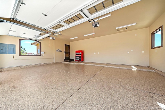 garage featuring electric panel, baseboards, and a garage door opener
