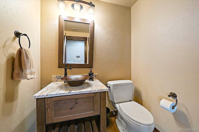 half bathroom featuring toilet and vanity
