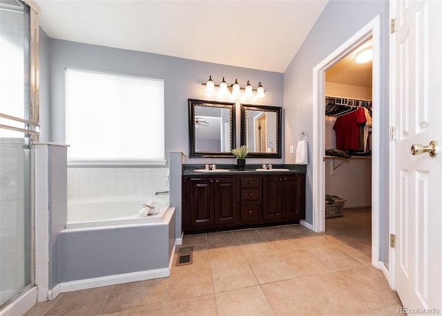 bathroom with tile patterned flooring, a sink, a garden tub, and visible vents