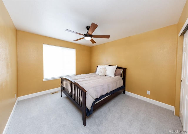 bedroom with light carpet, a ceiling fan, and baseboards