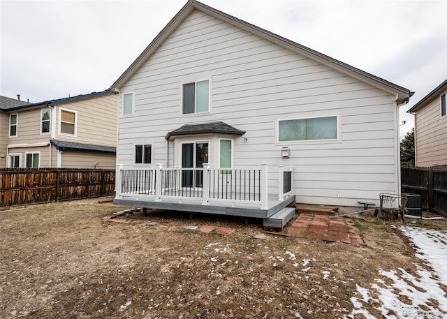 rear view of property featuring a wooden deck and a fenced backyard