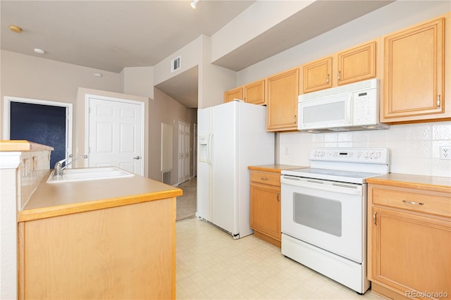 kitchen featuring light brown cabinetry, sink, white appliances, and tasteful backsplash