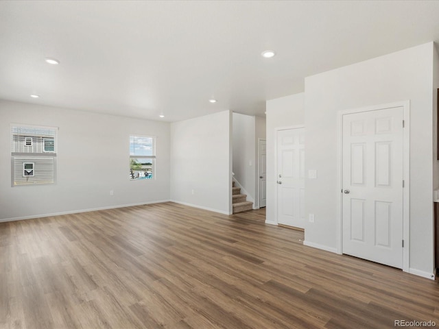 2717 73rd Avenue Ct, Greeley, CO 80634 - spare room with wood finished floors, stairway, baseboards, and recessed lighting