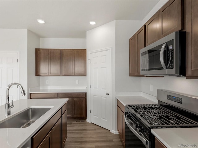 2717 73rd Avenue Ct, Greeley, CO 80634 - kitchen with stainless steel appliances, a sink, wood finished floors, light countertops, and recessed lighting
