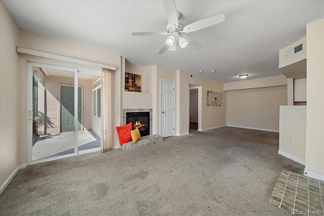 unfurnished living room with carpet, visible vents, a fireplace, and baseboards