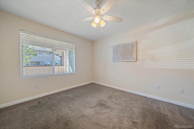 carpeted empty room featuring baseboards and a ceiling fan