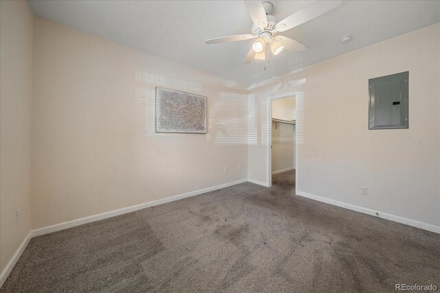 unfurnished room with carpet, electric panel, baseboards, and ceiling fan