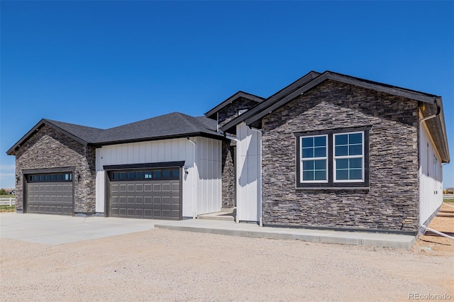 56159 E Tomahawk Ave, Strasburg, CO 80136 - view of front of home with stone siding, an attached garage, and driveway